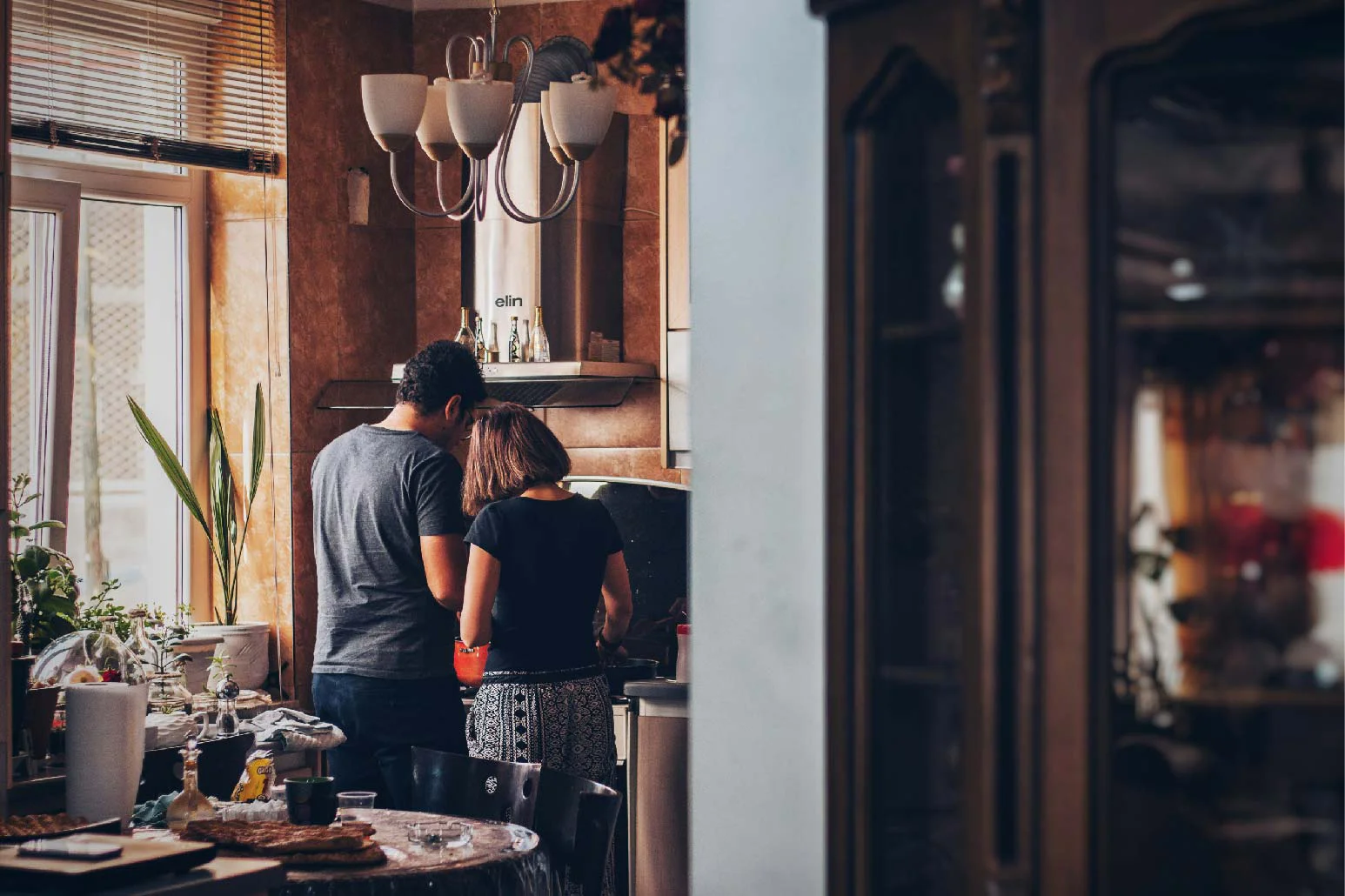 a middle-aged couple cooking in a rustic kitchen